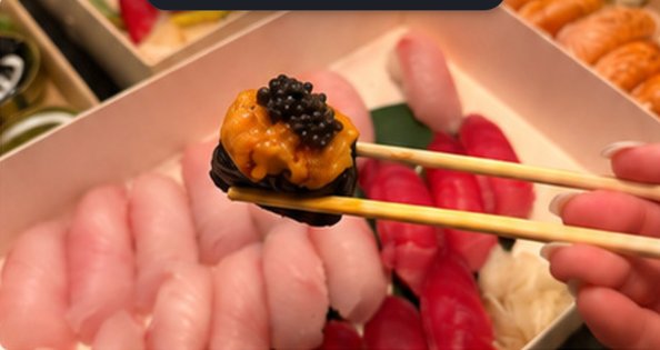 Premium nigiri with uni and caviar lifted with chopsticks
